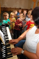 Педагог учит детей петь, фотоизображения маленьких музыкантов