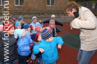 Мужчина-педагог играет с детьми в ролевые игры на детской площадке, фотографии играющих малышей