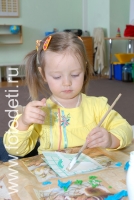 Маленькая девочка клеит с помощь кисти, на фотографии ребёнка из галереи «Детское творчество
