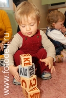 Ребёнок строит башню из кубиков Зайцева, снимок из архива детского фотографа