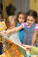Дети играют и общаются с книгой, снимок из архива детского фотографа