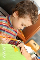Курчавый мальчуган рисует, фотография из галереи «Дети рисуют
