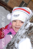Девочка прячется за зимним деревом, фотографии играющих малышей