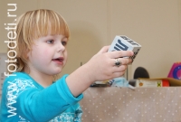 Фотография девочки с кубиком, снимок из архива детского фотографа