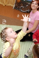 Ребёнок играет с мыльными пузырями на развивающих занятиях в детском центре, фото детей в фотобанке fotodeti.ru