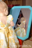Маленькая девочка в платьице любуется своим отражением в зеркале, фотография детского фотографа Игоря Губарева
