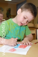 Мальчик выполняет рисунок карандашами, фотография из галереи «Дети рисуют