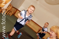 Бег детей по физкультурному залу, на фото дети занимаются спортом