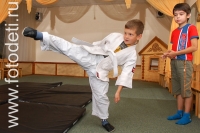 Мальчик в кимоно бьёт ногой, на фото дети занимаются спортом