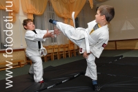 Поединок юных спортсменов в кимоно, на фото дети занимаются спортом