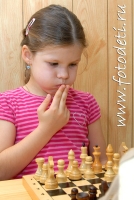 Девочка увлечённо играет в шахматы, забавные фотографии детей на сайте детского фотографа