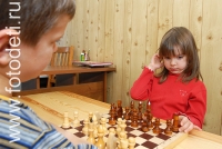 Ребёнок обдумывает шахматный ход, на фото дети занимаются спортом