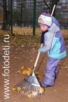 Мальчик убирает сухие листья на детской площадке в детском саду , любимые занятия детей