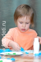 Девочка наклеивает обрывки цветной бумаги на картонную тарелочку, на фотографии ребёнка из галереи «Детское творчество