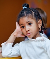 Девочка из английского детского сада внимательно слушает учителя. Фотосъёмка детей в детских садах и в семье.