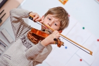 Мальчик играет на скрипке на новогоднем утренике. Фото малышей на интернет-сайте Игоря Губарева.