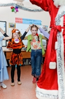 Фрагмент костюма Деда Мороза в кадре одновременно служит и передним планом и снимает у зрителя фото вопрос о том, что это за событие. Примеры фото детей.